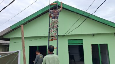 Satgas TMMD Ke-129 Lanjutkan Pengecatan Dinding Luar RTLH Milik Bapak Suhardin